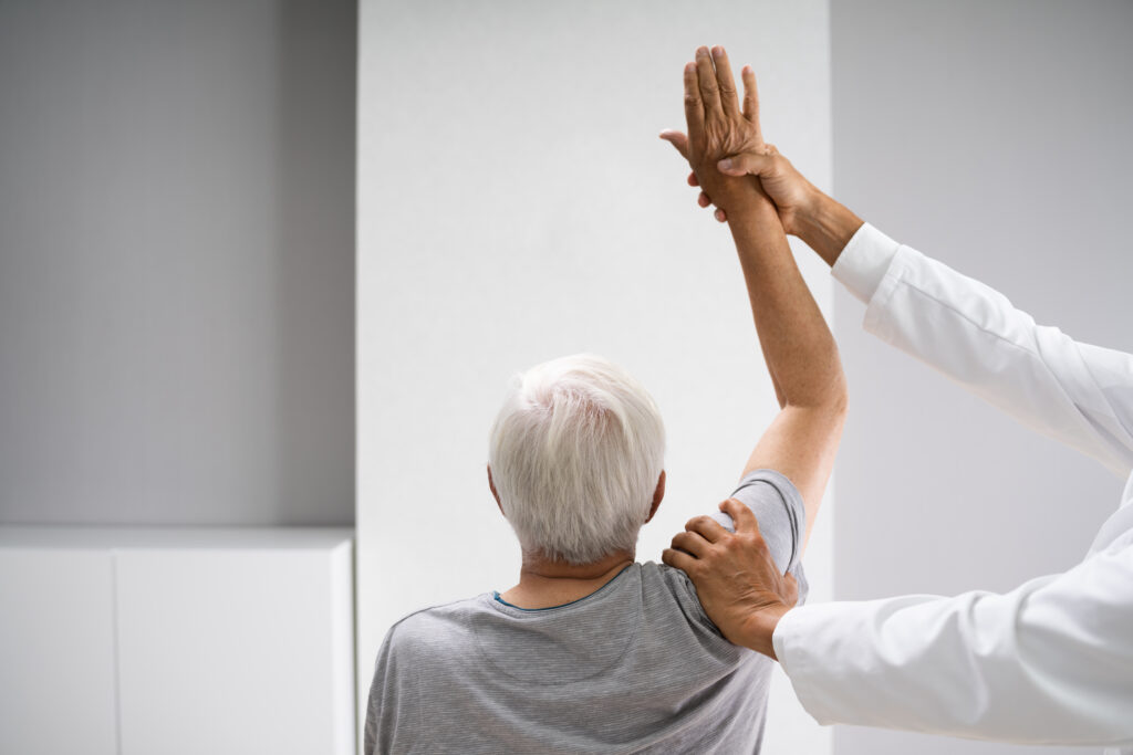 An elderly man receives guided physical therapy for seniors, focusing on mobility and strength recovery. This occupational therapy for elderly individuals helps improve independence and overall well-being.